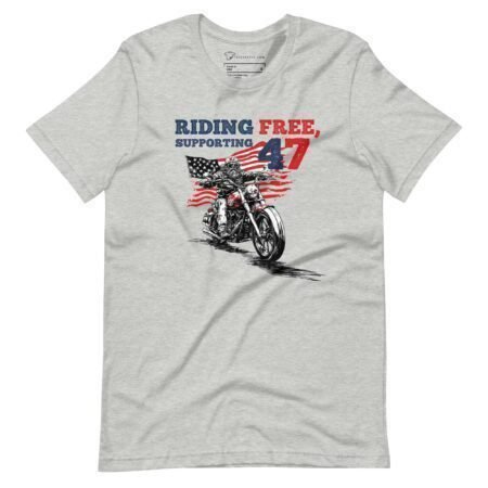 The "Riding Free | Elections 2024" unisex t-shirt is gray and features a graphic of a motorcycle and an American flag, with the text "Riding Free, Supporting 47" in red and blue. This t-shirt is perfect for showcasing your love for freedom and the upcoming elections in 2024.