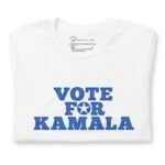 A neatly folded white unisex t-shirt titled "VOTE FOR KAMALA | Elections 2024" showcases a blue-lettered message with a star in the letter 'O,' making it ideal for expressing your support in the upcoming elections.