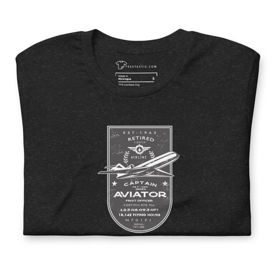 A folded dark gray unisex T-shirt, named "Pioneer | Airline Jet 727 | Retired Aviator," featuring a graphic design of an airplane with aviation-themed text: "Retired Airline Captain Aviator" and additional details like flight hours and certification numbers.