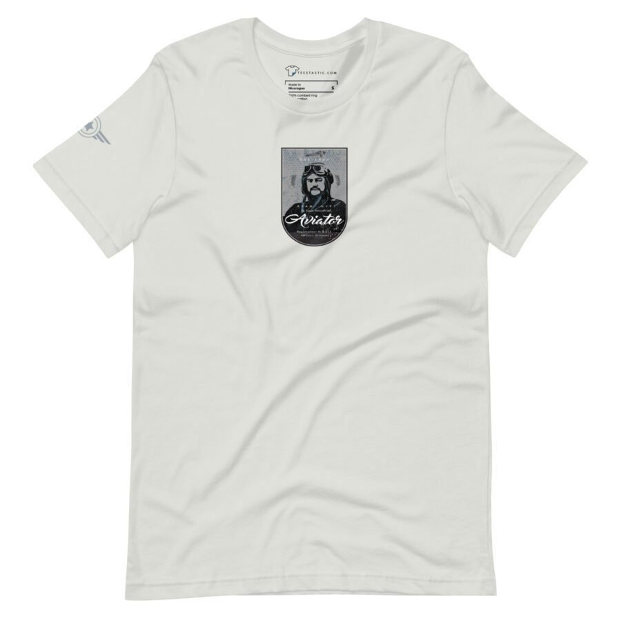 The Pioneer Aviator Unisex T-shirt from St. Louise Aircraft showcases a graphic of a pioneer aviator wearing goggles and a flight cap in the center, with the St. Louise Aircraft logo on the left sleeve.